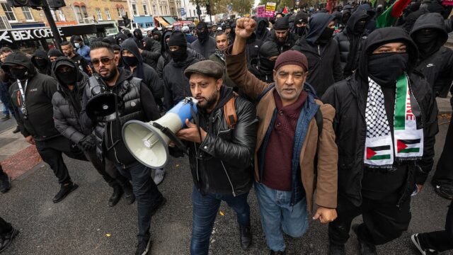 103309803-0-A_man_raises_his_fist_in_the_air_as_the_other_speaks_on_a_microp-a-14_1761601479173.jpg