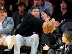 Justin Herbert, de los Chargers, defiende a Madison Bear con la pelota de baloncesto durante un partido de los Lakers.