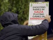 Manifestantes musulmanes enmascarados colocan carteles de “Los sionistas no son bienvenidos” en Birmingham antes del partido del Aston Villa contra un equipo israelí mientras 700 policías se preparan y las escuelas cierran temprano.