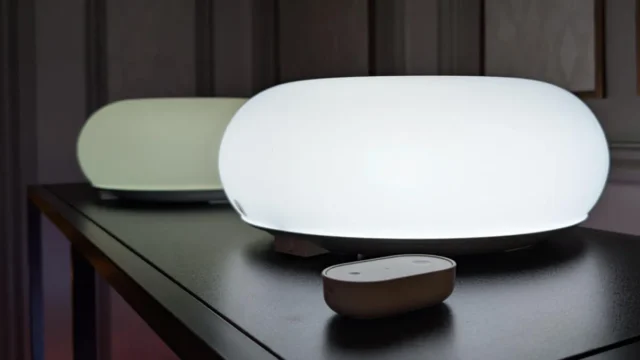 ikea-varmblixt-smart-donut-lamp-and-bilresa-remote-control-on-black-metal-shelf-in-ces-2026-display.webp