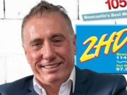 El jefe de 2HD Radio, Guy Ashford, jadea en el escenario mientras la presentadora de ‘Grops’ Cheryl Darcy acepta un premio