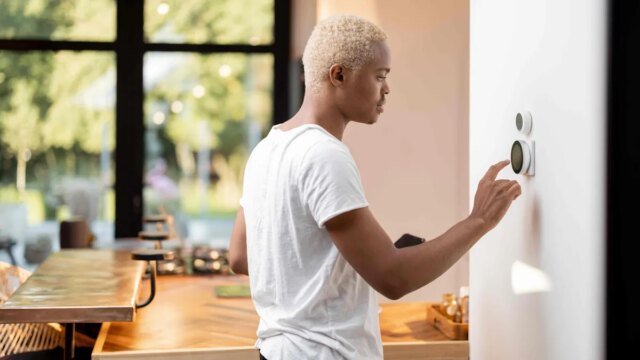shutterstock-man-taps-smart-thermostat.jpg