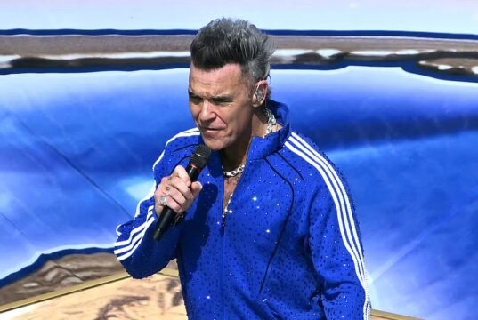 Robbie Williams inició la fiesta con un chándal Adidas de lentejuelas mientras iniciaba la final de la Copa del Mundo repleta de estrellas con una actuación previa al partido.