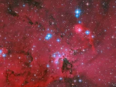 El Hubble de la NASA capturó un vivero estelar carmesí brillando con estrellas azules y blancas